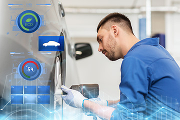 Image showing mechanic with screwdriver changing car tire