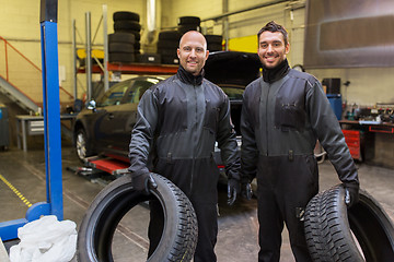 Image showing auto mechanics changing car tires at workshop