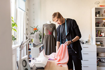 Image showing fashion designer with cloth making dress at studio