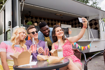 Image showing happy young friends taking selfie at food truck