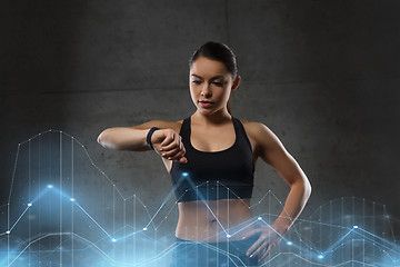 Image showing young woman with heart-rate watch in gym