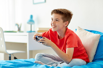 Image showing happy boy with gamepad playing video game at home