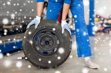 Image showing auto mechanic changing car tire at workshop