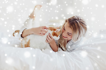 Image showing happy young woman with cat in bed at home