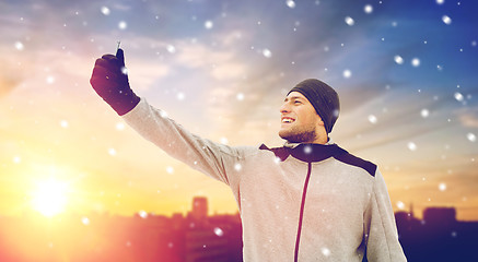 Image showing man taking selfie with smartphone in winter 