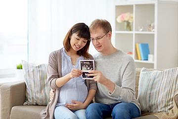 Image showing happy couple with ultrasound images at home