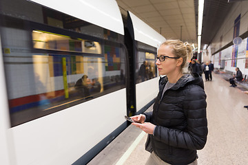 Image showing Woman with a cell phone waiting for metro.