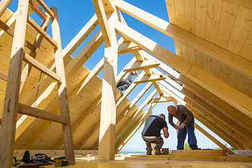 Image showing Builders at work with wooden roof construction.