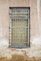 Image showing abandoned cracked stucco wall with window grilles