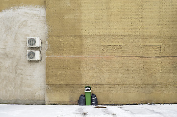 Image showing Green recycle bin near the large brick wall