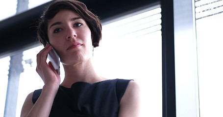 Image showing Business Girl Standing In A Modern Building Near The Window With