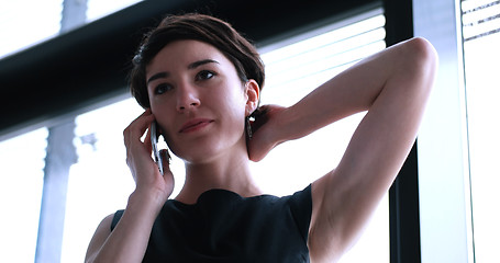 Image showing Business Girl Standing In A Modern Building Near The Window With