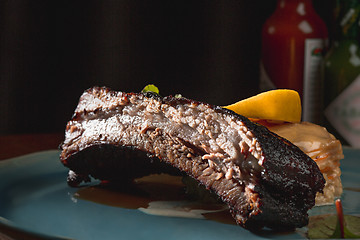 Image showing grilled pork ribs on dark plate