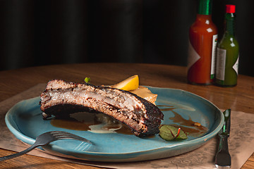 Image showing grilled pork ribs on dark plate
