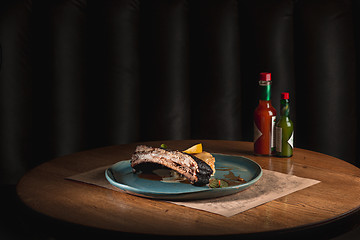 Image showing grilled pork ribs on dark plate