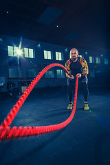 Image showing Men with battle rope battle ropes exercise in the fitness gym. CrossFit.