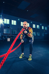 Image showing Men with battle rope battle ropes exercise in the fitness gym. CrossFit.