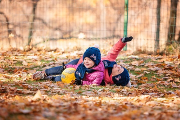 Image showing The two little baby girls playing in autumn leaves