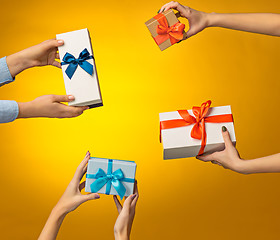 Image showing The closeup picture of man and woman\'s hands with gift box