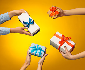 Image showing The closeup picture of man and woman\'s hands with gift box