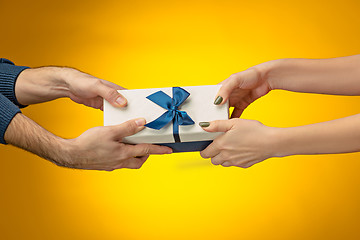 Image showing The closeup picture of man and woman\'s hands with gift box