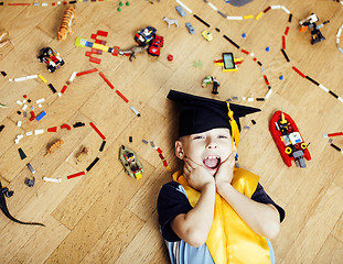 Image showing little cute preschooler boy among toys at home in graduate