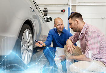 Image showing auto mechanic with clipboard and man at car shop