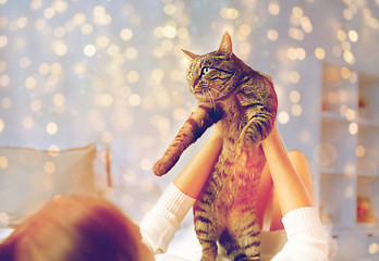 Image showing young woman with cat lying in bed at home