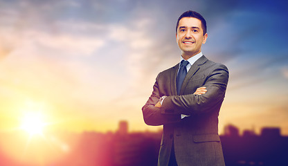 Image showing happy smiling businessman over city background