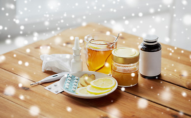 Image showing drugs, thermometer, honey and cup of tea on wood