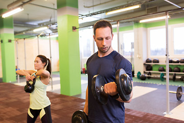 Image showing man and woman with kettlebell exercising in gym