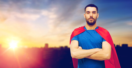 Image showing man in red superhero cape over city background