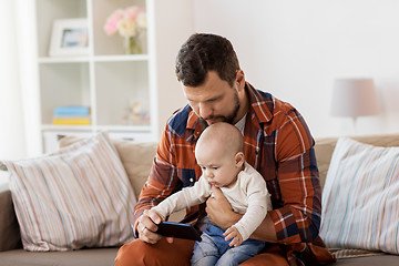 Image showing father and baby boy with smartphone at home