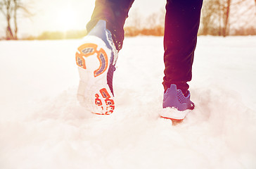 Image showing close up of feet running along snowy winter road