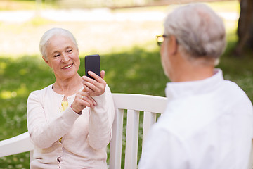 Image showing old woman photographing man by smartphone in park