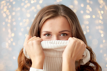 Image showing young woman or teen girl pulling pullover collar