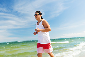 Image showing happy man running along summer beach