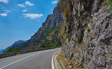 Image showing Asphalt road. Colorful landscape with beautiful mountain road with a perfect asphalt. High rocks, blue sky at sunrise in summer. Vintage toning. Travel background. Highway at mountains