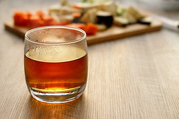 Image showing Tea in a glass on a wooden table