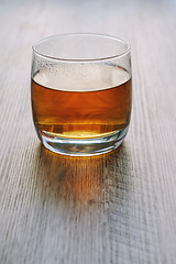 Image showing Tea in a glass on a wooden table