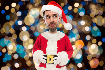 Image showing sad man in santa costume over christmas lights