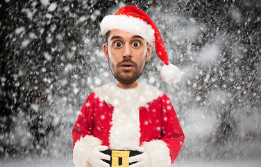 Image showing man in santa claus costume over christmas snow