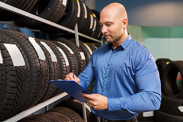 Image showing auto business owner and wheel tires at car service