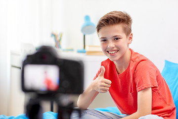 Image showing happy boy with camera recording video at home