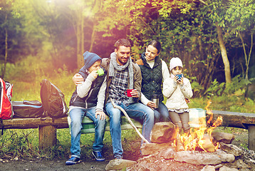 Image showing happy family sitting on bench at camp fire