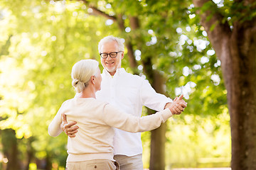 Image showing happy senior couple dancing at summer park