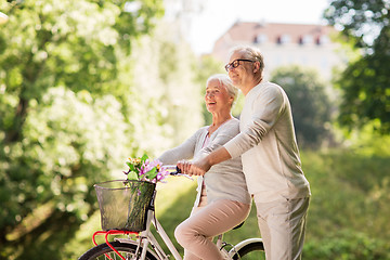 Image showing happy senior couple with bicycle at summer park