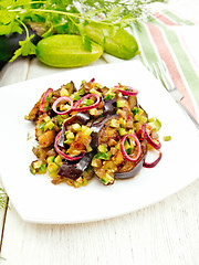 Image showing Salad from eggplant and cucumber with onion in plate on light bo