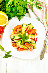 Image showing Salad with zucchini and tomato in plate on light board top