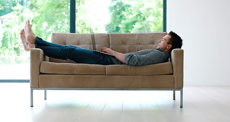 Image showing Man using laptop in living room